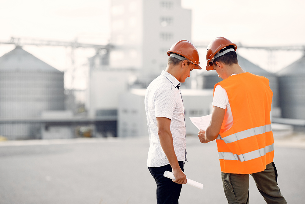 engineers-in-helmets-standing-by-the-factory